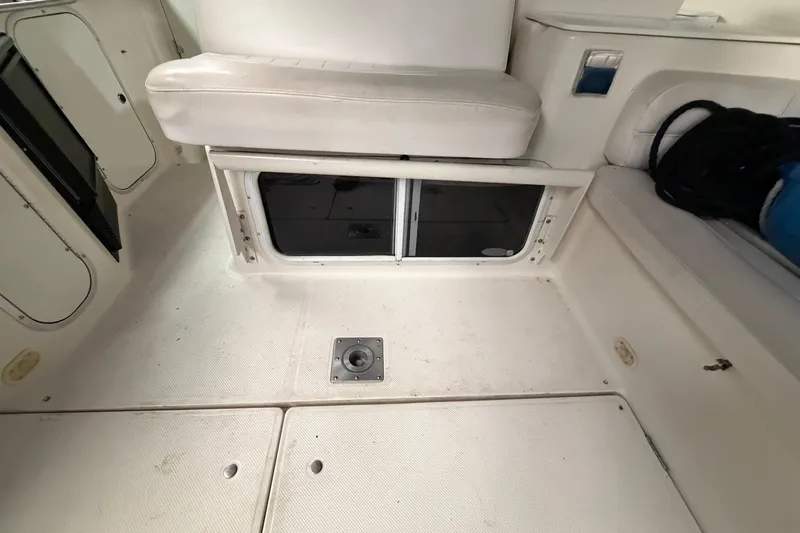Slide: The Image of Interior of a 2001 Maxum 3300 SCR boat, featuring white seating and storage compartments. - 18