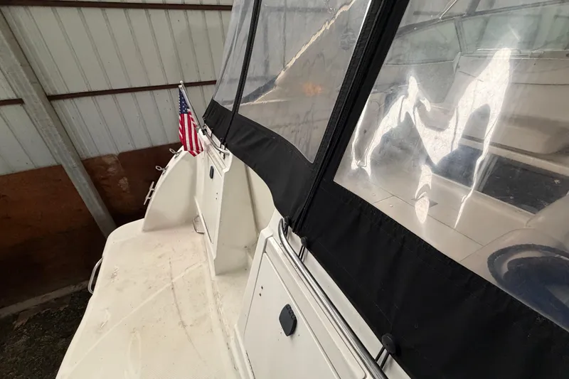 Slide: The Image of 2001 Maxum 3300 SCR boat with American flag, docked indoors. - 45