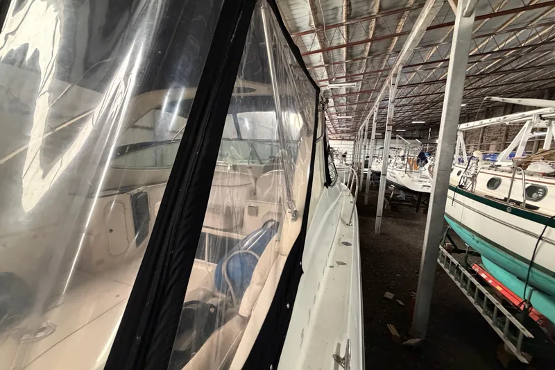 Slide: The Image of 2001 Maxum 3300 SCR boat in storage, covered with clear protective tarp. - 48