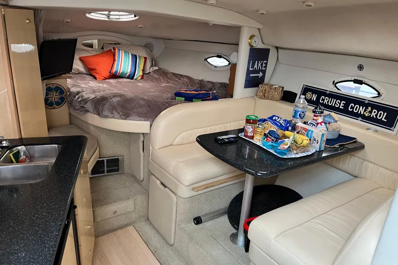 Slide: The Image of Cozy interior of 2001 Maxum 3300 SCR boat with bed, dining area, and snacks. - 8