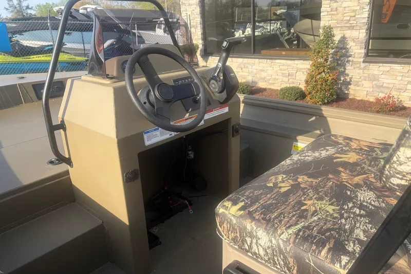 Slide: The Image of 2026 G3 Gator Tough Tunnel Jon 18 CCJ boat interior with camo seat and steering console. - 8