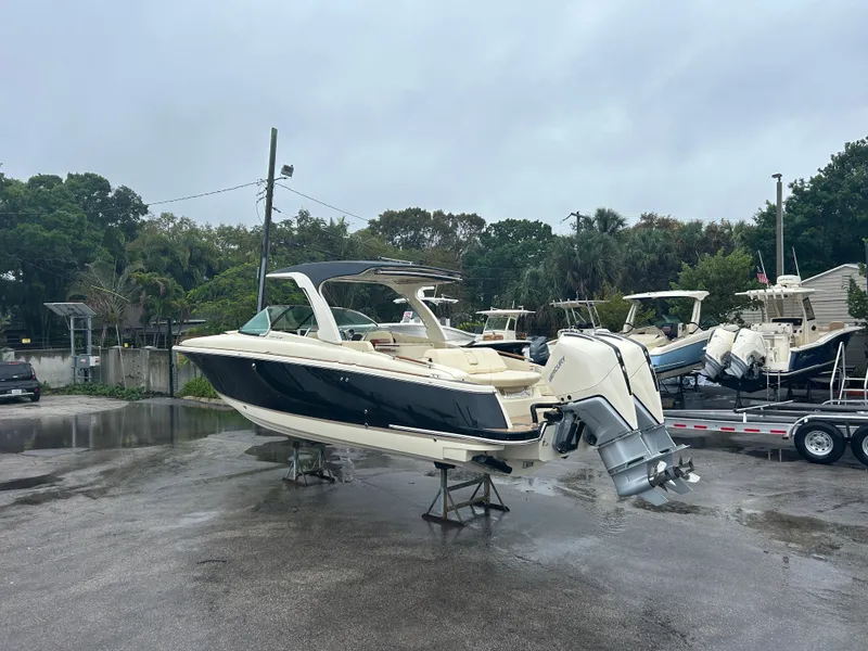 Slide: The Image of 2026 Chris-Craft Launch 31 GT boat on a wet parking lot. - 1