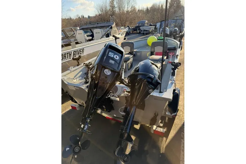 Slide: The Image of 2021 Smoker Craft 16 Lodge boat with dual outboard motors in a marina setting. - 5