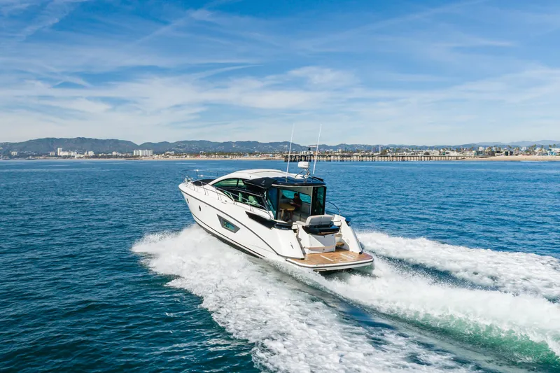Slide: The Image of 2019 Beneteau Gran Turismo 46 cruising on open water with cityscape in background. - 11