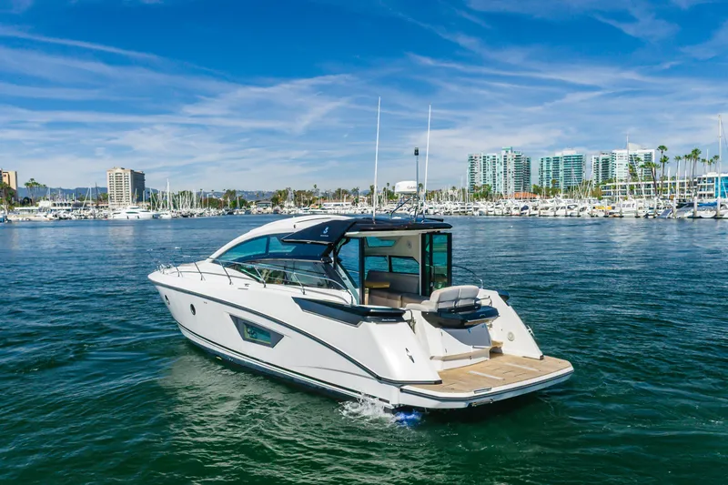Slide: The Image of 2019 Beneteau Gran Turismo 46 yacht cruising in a marina with cityscape background. - 2
