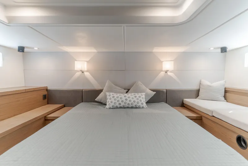 Slide: The Image of Luxurious cabin interior of 2019 Beneteau Gran Turismo 46 yacht, featuring elegant bedding and lighting. - 33