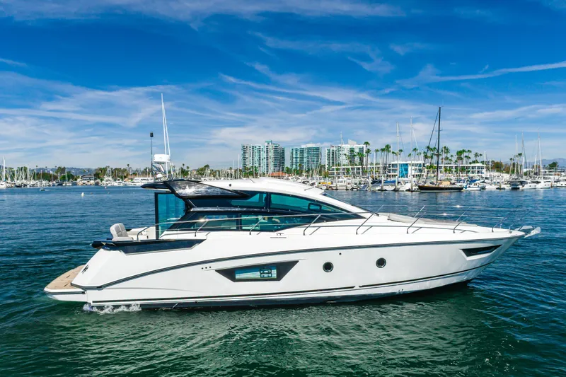Slide: The Image of 2019 Beneteau Gran Turismo 46 yacht cruising in a marina under a clear blue sky. - 5