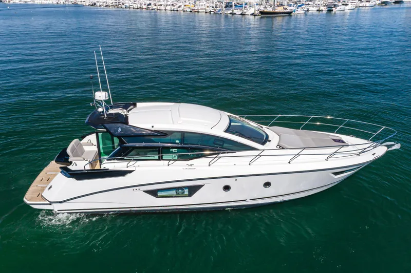 Slide: The Image of 2019 Beneteau Gran Turismo 46 yacht cruising on calm waters near a marina. - 6
