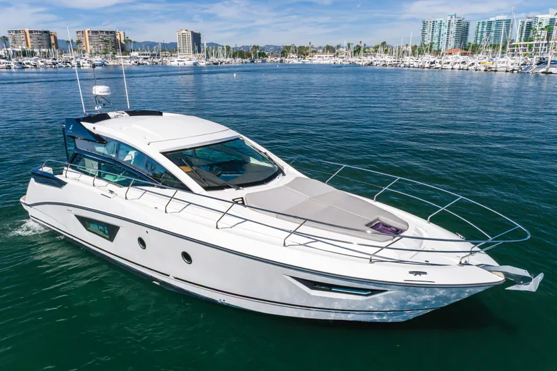 Slide: The Image of 2019 Beneteau Gran Turismo 46 yacht cruising in a marina with cityscape background. - 7