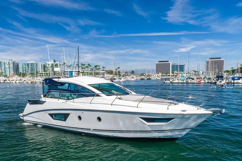 Slide: The Image of 2019 Beneteau Gran Turismo 46 yacht cruising in a marina with cityscape background. - 8
