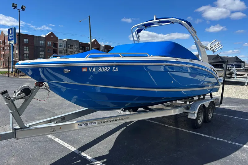 Slide: The Image of 2017 Chaparral 227 SSX Surf boat in vibrant blue on a trailer, parked outdoors. - 13