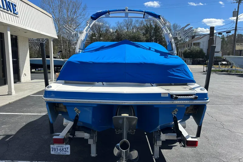 Slide: The Image of 2017 Chaparral 227 SSX Surf boat with blue cover, parked outdoors. - 15