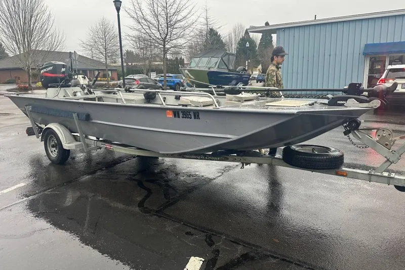 The Image of 2002 Smoker Craft Sportsman 1860 DLX boat on trailer in parking lot. - 1