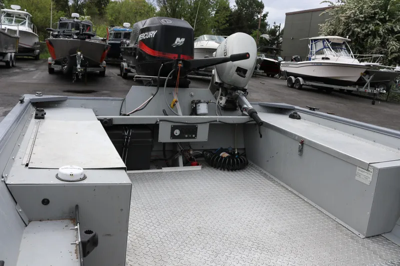 Slide: The Image of 2002 Smoker Craft Sportsman 1860 DLX boat with Mercury outboard motor, parked among other boats. - 7
