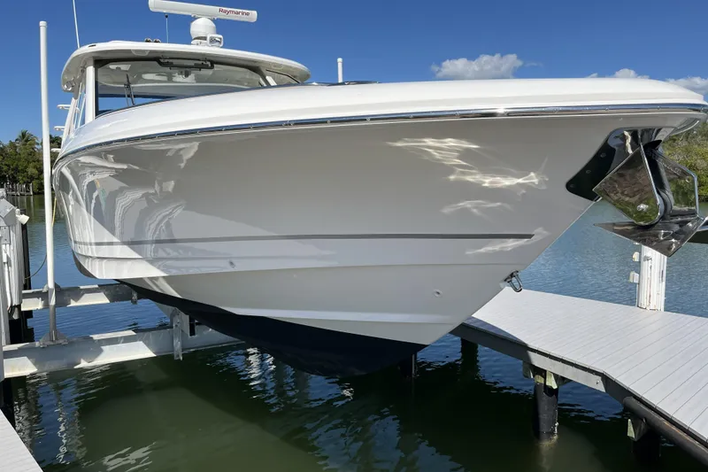 Slide: The Image of 2022 Boston Whaler 380 Realm boat docked on a lift, sunny day. - 17