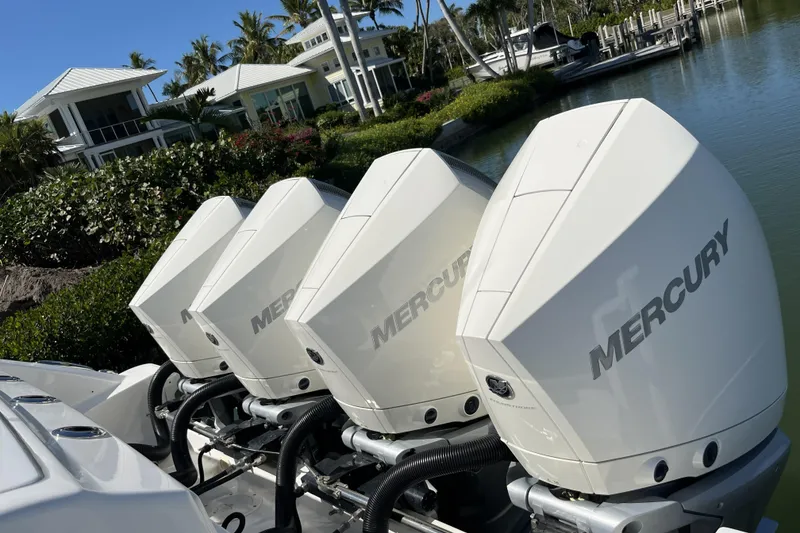 Slide: The Image of Four Mercury outboard engines on a 2022 Boston Whaler 380 Realm, docked near luxury homes. - 19