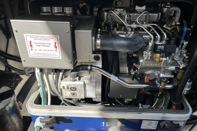 Slide: The Image of Engine compartment of a 2022 Boston Whaler 380 Realm, featuring high voltage warning. - 22