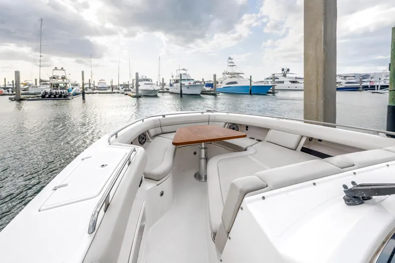Slide: The Image of 2022 Boston Whaler 380 Realm boat docked in marina, featuring spacious seating and table. - 23