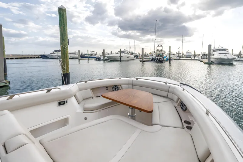 Slide: The Image of 2022 Boston Whaler 380 Realm boat interior with seating and table, docked in marina. - 24