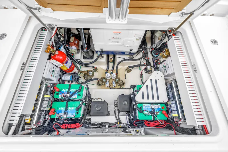 Slide: The Image of Engine compartment of a 2022 Boston Whaler 380 Realm, showcasing batteries and equipment. - 28