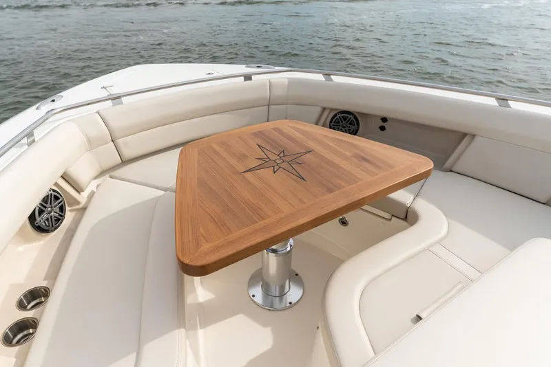 Slide: The Image of Manufacturer Provided Image: Luxury seating area on 2022 Boston Whaler 380 Realm boat with wooden table. - 4