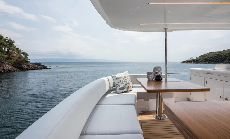 Slide: The Image of Luxurious Sirena 48 yacht deck with ocean view, featuring elegant seating and dining area, 2025 model. - 19