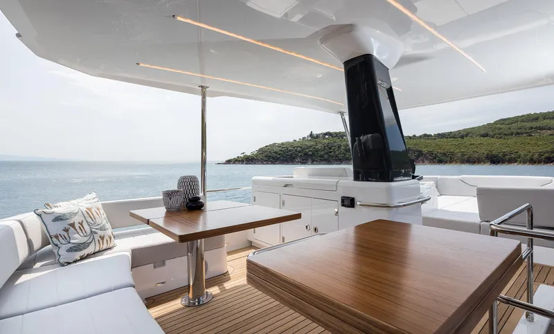 Slide: The Image of Luxurious 2025 Sirena 48 yacht deck with elegant seating and wooden tables, overlooking serene waters. - 18