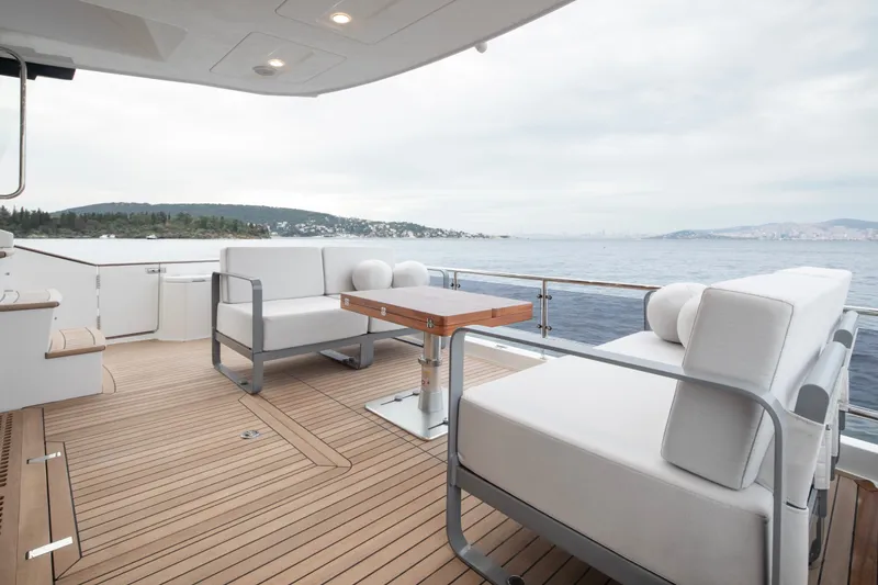 Slide: The Image of Luxurious Sirena 48 yacht deck with modern seating, overlooking serene ocean view, 2027 model. - 21