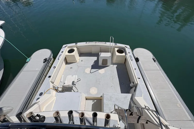 Slide: The Image of 1983 Hatteras Yachts 32 model, spacious deck view, docked on calm water. - 2