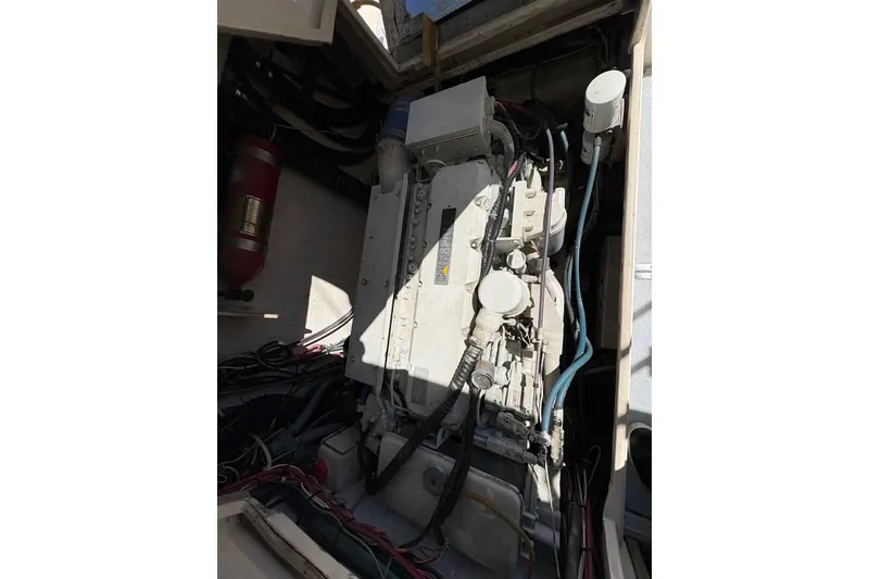 Slide: The Image of Engine compartment of a 1983 Hatteras Yachts 32, showcasing mechanical components and wiring. - 3