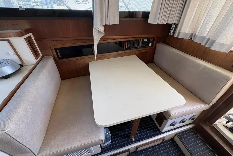 Slide: The Image of Interior of 1983 Hatteras Yachts 32, featuring a cozy dining area with a table. - 6