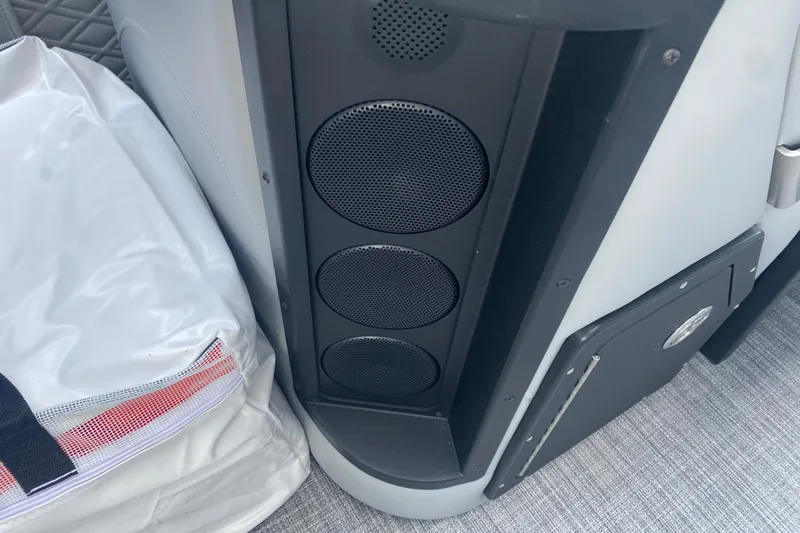 Slide: The Image of Speakers and storage compartment on a 2025 JC Sporttoon 26TT boat interior. - 13