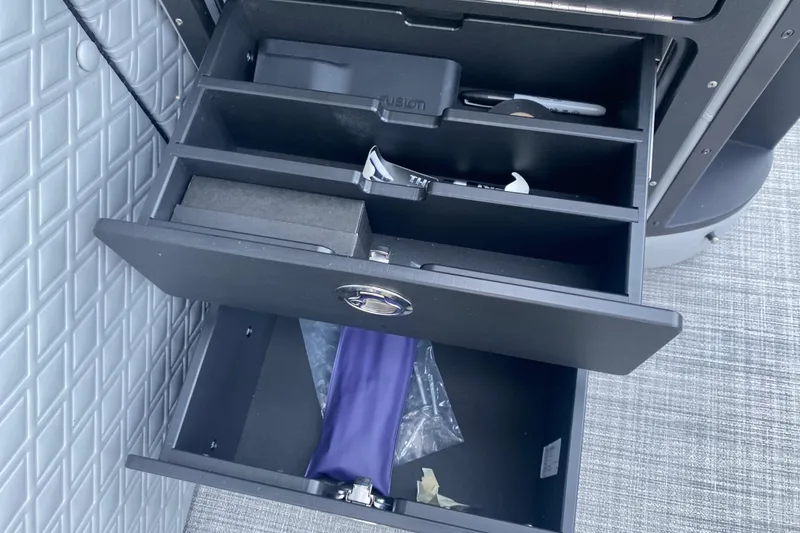 Slide: The Image of Open storage compartments in a 2025 JC Sporttoon 26TT boat, featuring organized sections. - 28