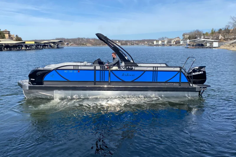 Slide: The Image of 2025 JC Sporttoon 26TT pontoon boat cruising on a lake with scenic background. - 3