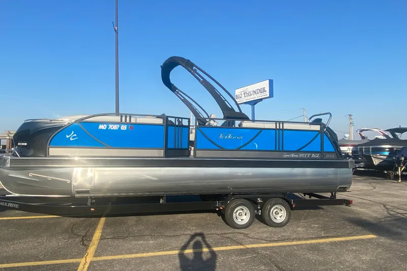 Slide: The Image of 2025 JC Sporttoon 26TT pontoon boat on trailer in parking lot, blue and silver design. - 37