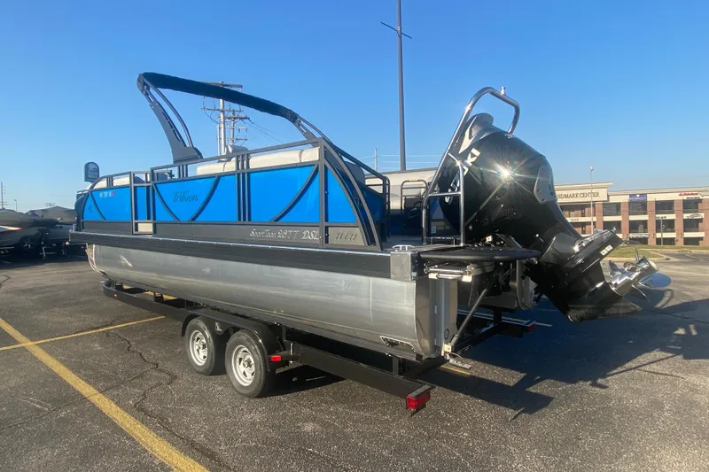 Slide: The Image of 2025 JC Sporttoon 26TT pontoon boat on trailer, featuring sleek blue design and powerful outboard motor. - 39