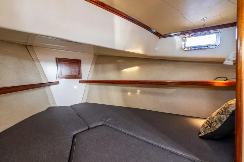 Slide: The Image of Cozy cabin interior of 1999 Northern Bay 36 boat with cushioned seating and wooden accents. - 18