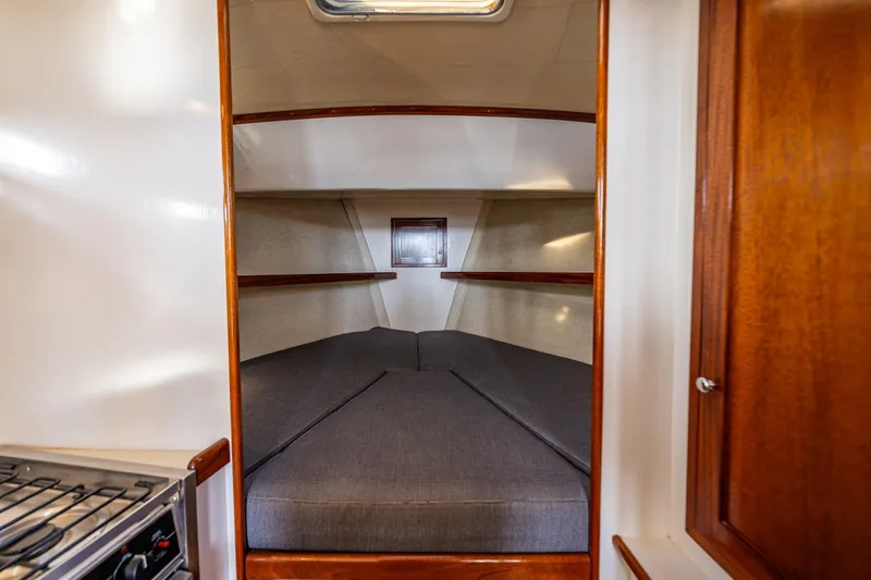 Slide: The Image of Cozy cabin interior of 1999 Northern Bay 36 boat with cushioned berth and wooden accents. - 20