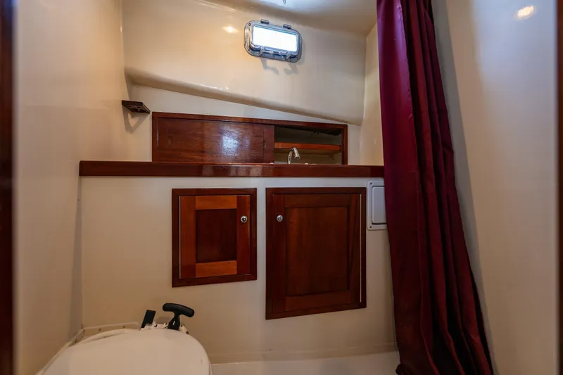 Slide: The Image of Interior of 1999 Northern Bay 36 boat with wooden cabinets and maroon curtain. - 21