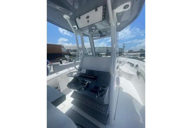 Slide: The Image of 2023 Tidewater 292 CC Adventure boat interior with steering console and controls. - 11