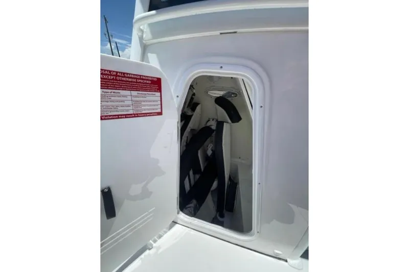 Slide: The Image of 2023 Tidewater 292 CC Adventure boat storage compartment with safety equipment. - 14