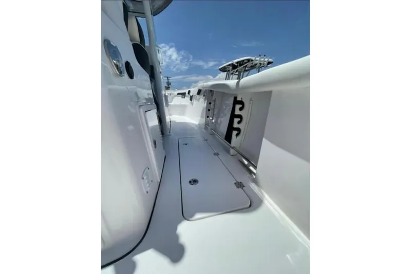Slide: The Image of 2023 Tidewater 292 CC Adventure boat deck with storage compartments under clear blue sky. - 15