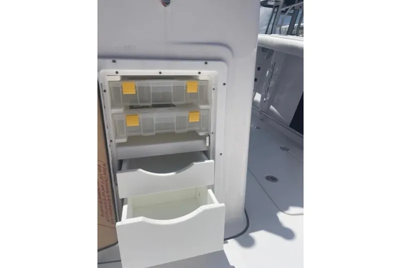 Slide: The Image of Storage compartments on 2023 Tidewater 292 CC Adventure boat, featuring organized tackle boxes. - 17
