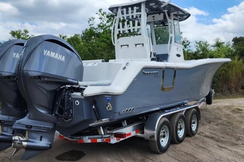 Slide: The Image of 2023 Tidewater 292 CC Adventure boat with dual Yamaha engines on a trailer. - 2