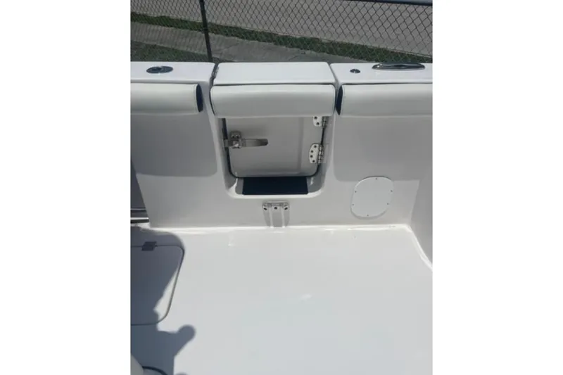 Slide: The Image of 2023 Tidewater 292 CC Adventure boat interior, featuring a sleek white deck and storage compartment. - 8