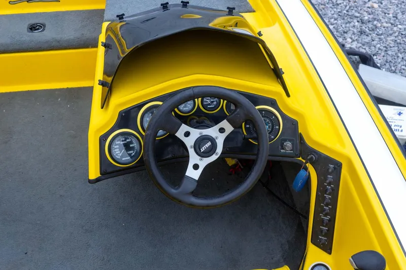 Slide: The Image of Yellow 2002 Bullet 20XDC boat dashboard with steering wheel and gauges. - 21