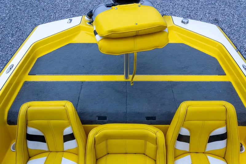 Slide: The Image of Yellow and gray interior of a 2002 Bullet 20XDC boat with cushioned seats. - 26