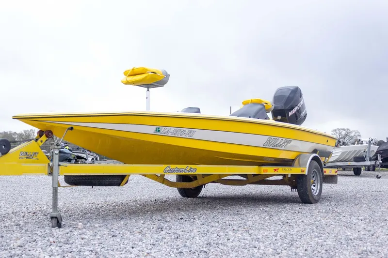 Slide: The Image of Yellow 2002 Bullet 20XDC boat on trailer, parked on gravel lot. - 3