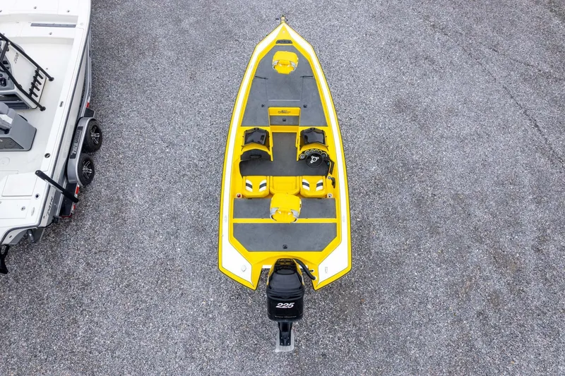 Slide: The Image of Yellow 2002 Bullet 20XDC boat with outboard motor, parked on gravel next to a trailer. - 37