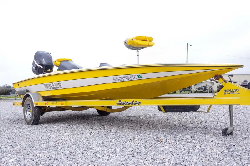 Slide: The Image of Yellow 2002 Bullet 20XDC boat on trailer, parked on gravel. - 5